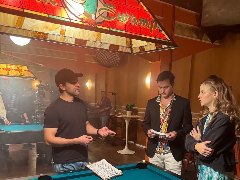 Rishi Kara directing two actors beside a pool table